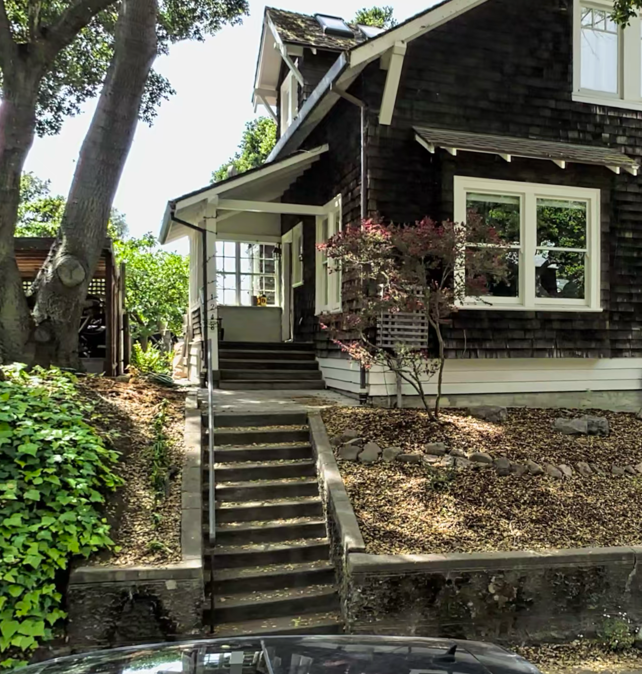 A craftsman-style home with concrete front steps leading up to the porch — no handrail on the upper portion